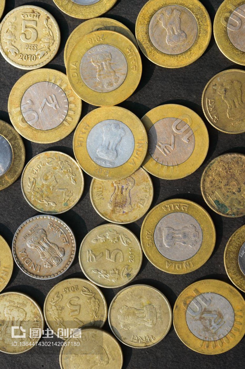 金色印度卢比硬币货币在乡村地板上的混合。全帧。桌面视图。垂直。商业金融和金融投资背景。特写